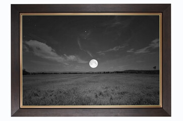 Black and white picture of full moon over the field
