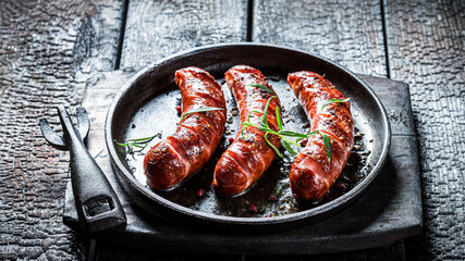 Closeup of grilled sausage on black burnt table