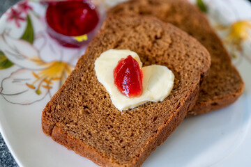 Heart shaped butter with jam on a slice of bread
