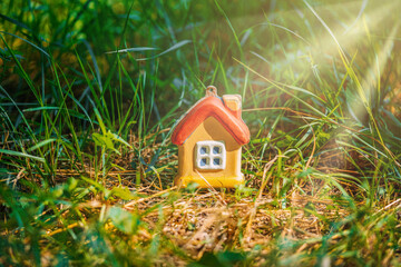 Fototapeta na wymiar a toy house in the grass under the sun