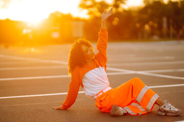 Stylish girl - dancer dancing in the street at sunset. Beautiful African  American woman with curly...