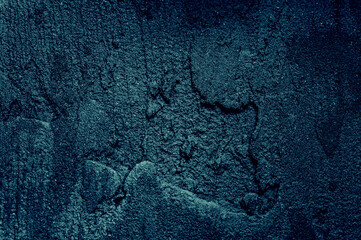 Beautiful dark blue texture background with light shine. Dark background. The rough surface of the plaster.