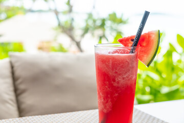 Selective focus at watermelon  juice with Composable plastic straw with beach and sea blurred...