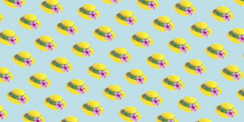 Yellow straw summer hat with flower on light blue seamless background, bunner