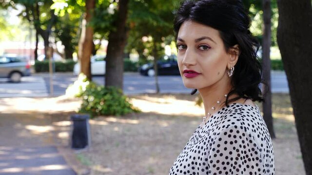 sensual woman in the city turning looking at camera and keeps walking