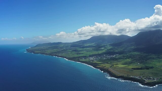 Aerial landscape of a blue sea and a green island with a black coast and Mount Liamiuga in Saint Kitts and Nevis