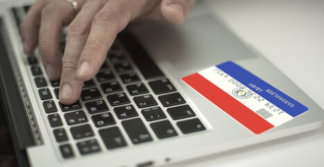 Man pays online with plastic bank card with printed flag of Paraguay. Fictional numbers