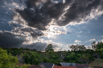 Fototapeta na wymiar Dramatic sky over village in Franconian Switzerland on sunny summer day