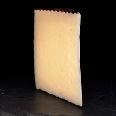Hard cured sheep cheese from Spain on black slate board