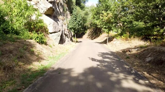 Point of view shot of riding a bicycle at Amarante Cycling Trail in Portugal. Features a wide view of the bike track and the natural scenery as it travels.