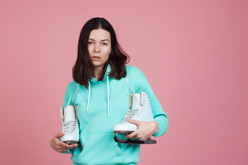 Figure skating for adults, Hobbies and a healthy lifestyle. A young woman in a bright sweatshirt...