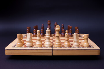 A game of chess, the beginning of a chess game two sides opposite each other.