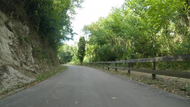 Point of view shot of riding a bicycle at Amarante Cycling Trail in Portugal. Features a wide view of the bike track and the natural scenery as it travels.