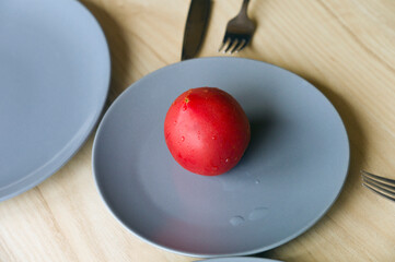 Whole red tomato on a plate