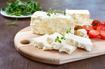 Delicious healthy sheep or goat feta cheese. Chunks of cheese on a wooden board.