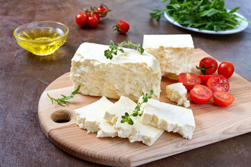 Fototapeta na wymiar Delicious healthy sheep or goat feta cheese. Chunks of cheese on a wooden board.