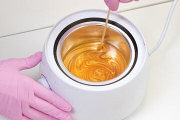 Wax for hair removal. Molten wax in a special container for heating the wax.