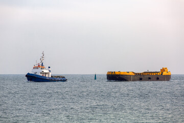 Fototapeta premium Tug rope pulls on the sea barge with sea sand.