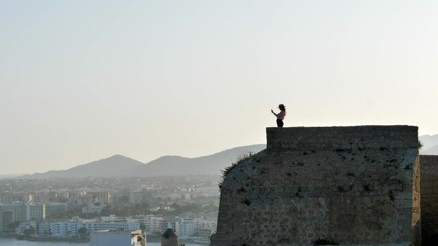 Silhouette of tourist taking pictures of Ibiza, wall of Dalt Vila. Static
