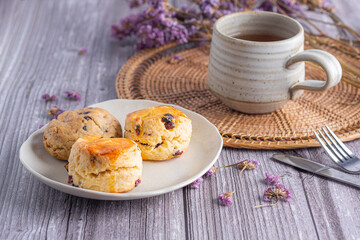 Traditional British scones and cookie with a tea cup and blurred background