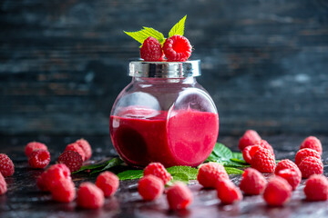 Appetizing raspberry puree in a glass jar and fresh raspberries. Concept of types to billet berries - obrazy, fototapety, plakaty