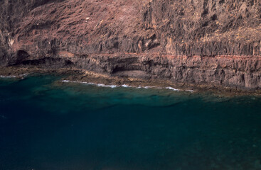 Obraz premium Gran Canaria, steep eroded coast line of Agaete municipality, path to Playa del Juncal beach 