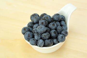 blueberries in a bowl on wooden background
