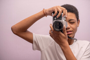 Horizontal shot of teenager taking photos with vintage camera