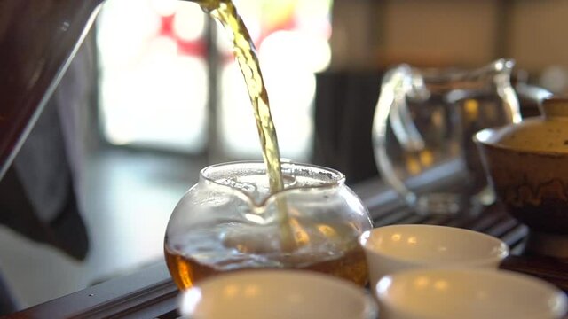 Pouring a High Quality tea while the Traditional Chinese tea ceremony is perfomed by tea master on Tea table - Chaban, Chahai and pial