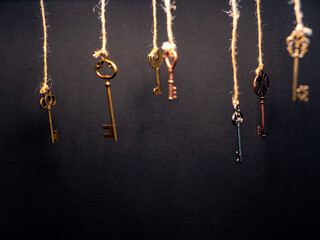 Plakat A lot of different old keys from different locks, hanging from the top on strings.