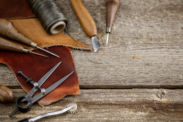 Leather craft tools on old wood table. Leather craft workshop.
