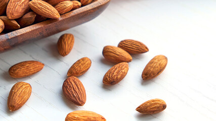Almonds nuts in wooden bowl on a white wooden table