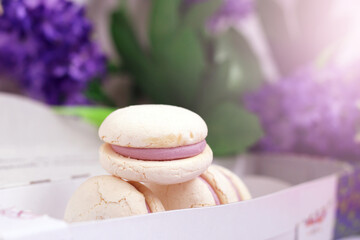White macaroons in a cardboard box, beautiful purple dessert.