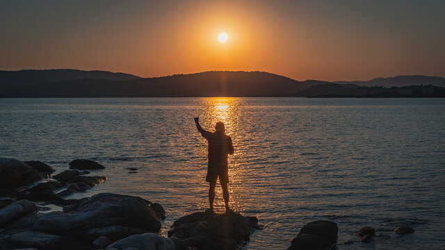 silhouette of Fisherman at evening next to the sea