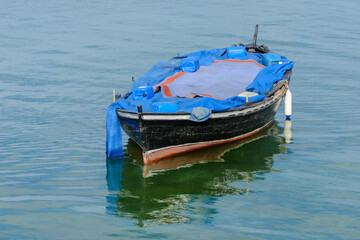 Fototapeta na wymiar wooden fishing boat with a motor anchored in the sea, calm natural landscape