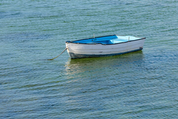 Naklejka na ściany i meble wooden fishing boat with a motor anchored in the sea, calm natural landscape