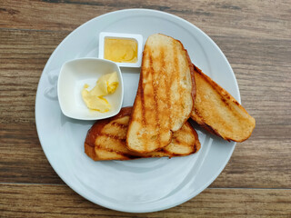 Toasts with butter and jam in white plate