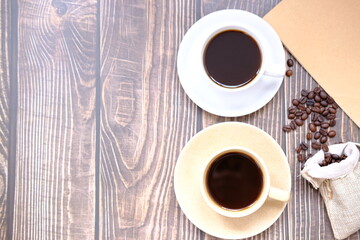coffee cup and coffee beans on old wood table background, space for text
