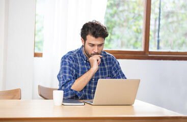 portrait of man working on his laptop, for work from home concept.