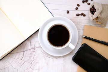 Top view cup of coffee and coffee beans on table background