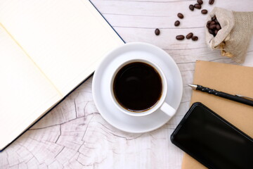 cup of coffee and coffee beans on table background