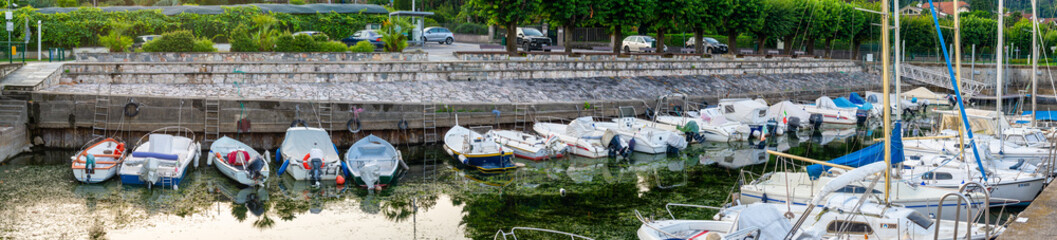 Panorama of harbor with boats moored in lake maggiore