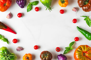 food composition. frame made of colorful organic vegetables. tomatoes, pepper, garlic and basil on white background
