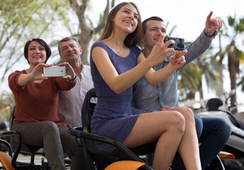 family of tourists enjoy a walk on the bike carriage