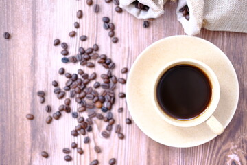 coffee cup and coffee beans on old wood table background, space for text