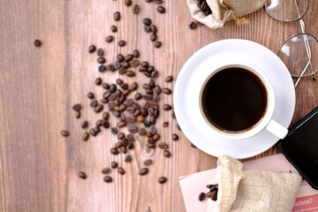 Top view coffee cup and coffee beans on old wood table background, space for text