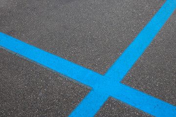 Fototapeta na wymiar blue parking strips crossing on asphalt road