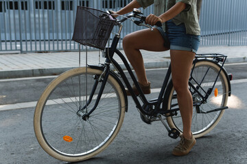 Fototapeta na wymiar Young girl sitting on her hipster bike in an urban setting