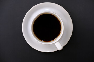 Top view cup of coffee and coffee beans on table background