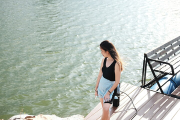 Beautiful young asian woman relaxing and standing on wooden bridge lonely in the park with natural...